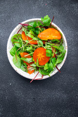 salad persimmon lettuce leaves mix green healthy meal food snack on the table copy space food background rustic top view keto or paleo diet veggie vegan or vegetarian food