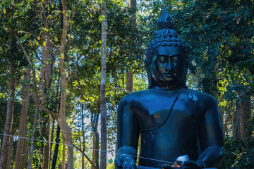 Nakhon Nayok, Thailand - January, 01, 2022 : The big black Buddha statue of the temple Chulabhorn wanaram temple Nakhon Nayok, Thailand.