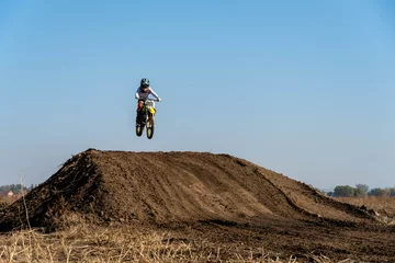 Foto op Plexiglas jumping on a motorcycle. motocross. motorcycle racing. bikers on the track © denis