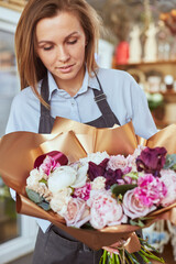 Florist with freshly made bouquet at flower shop