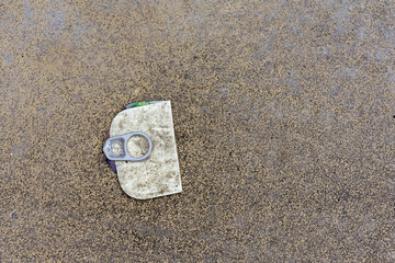 Old used tab from a tin or can lying on the street