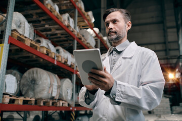 Man working on factory with tablet