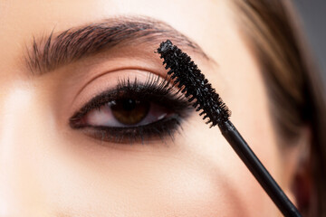 Eyebrow makeup. Beauty model shaping brows with brow pencil closeup. Beautiful woman contouring...