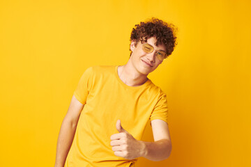 guy with red curly hair yellow t-shirt glasses fashion hand gestures yellow background unaltered