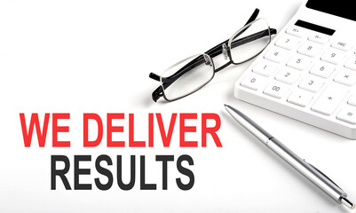 WE DELIVER RESULTS Concept. Calculator,pen and glasses on the white background