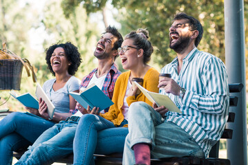 Group of young students sitting together in the park high school university campus