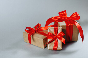 Gifts in kraft paper with red ribbon.