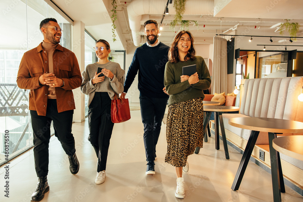 Wall mural Multiethnic businesspeople walking through a modern office