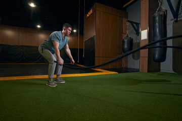 Obraz premium Focused young sportsperson training in fitness room