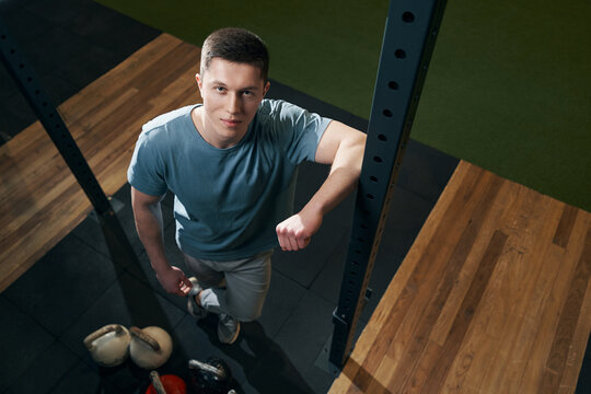 Pleased sportsman standing in fitness room during photo shoot