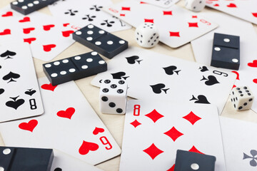 Dice, playing cards and dominoes for board games on light table close up.