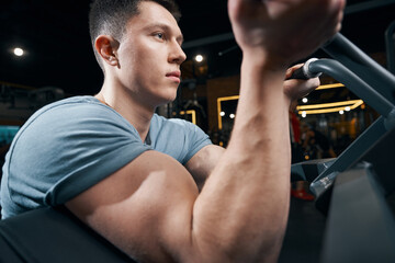 Professional bodybuilder is exercising on gym equipment