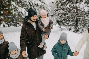 Father walking with his children in a park on snowy winter day.