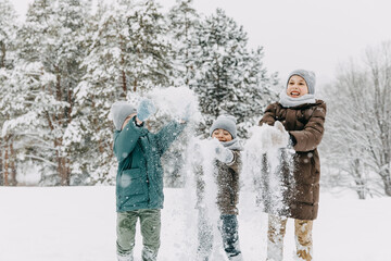 Kids playing in snow, laughing and throwing snow in the air.