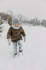 Fototapeta na wymiar Boy walking in deep snow in mountains.
