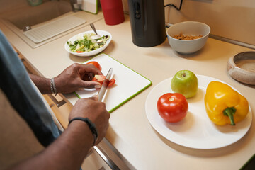 Man using big knife for cutting vegetables on table