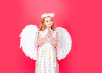 Child angel prayer. Child with angelic character. Toddler girl wearing angel costume white dress...