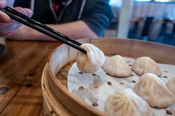 Close up view of xiao long bao in a steamer basket inside a restaurant