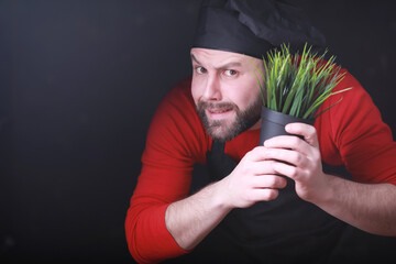 A young gardener cares for seedlings and cuts flowers.Gardener with a flower tray. Man who takes care of planting seedlings in the spring.