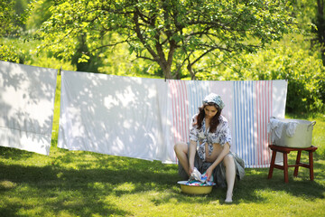 Fototapeta premium Pregnant woman hanging wash clothes on the rope for drying