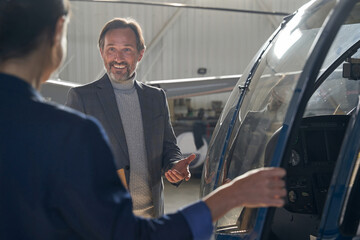 High-spirited aircraft hangar manager talking to his customer