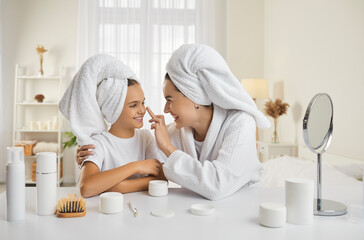 Mother and child having fun during skin care routine. Happy beautiful mommy and pretty little...