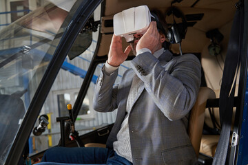Man playing a 3D simulation game in hangared chopper