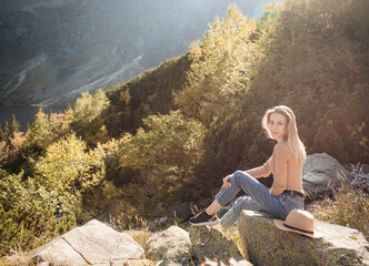 Young woman on a hiking trip sitting on a rock