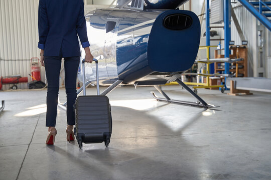 Business lady with baggage in aircraft hangar