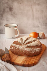 a loaf of bread on the on a wooden background with garlic and white cup