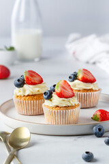 Cupcakes with berries on a plate, close-up