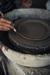 Hands of craftsman artist working on pottery wheel.