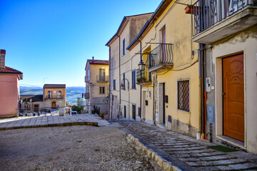 Fototapeta na wymiar A street among the characteristic houses of Casalbore, a mountain village in the province of Avellino, Italy.