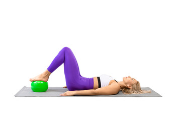 Caucasian fit woman lying on back with bent knees and a small fit ball under her feet, start position for gluteal bridge exercise, isolated on white.