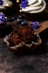 Chocolate cupcakes with blueberries on a dark table