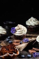 Chocolate cupcakes with blueberries on a dark table