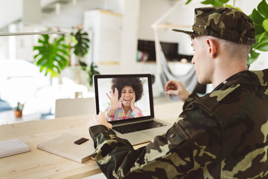 Young soldier man on video call with girlfriend through laptop at home