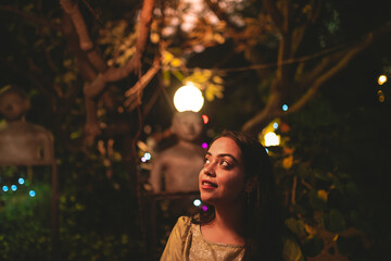 A girl looking at decorative lights at night party.