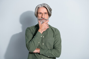 Portrait of attractive focused grey-haired man professor touching beard thinking isolated over gray pastel color background