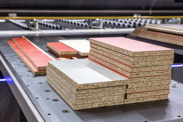 particle boards are stacked on a wood-cutting machine - 480897128