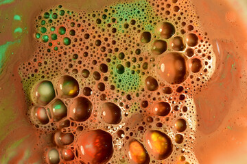 Transparent bubbles on a brown liquid background.