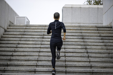 Fitness woman running up stairs in city