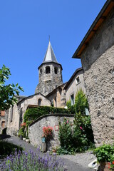 Belle église ancienne avec son clocher d'ardoises dominant un petit village dans le puy de dôme