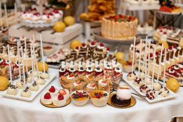Varied sweet wedding buffet. Festive event. Organization of banquets and weddings. Wedding floristry .Sweet cakes at. wedding banquet. Exquisite wedding desserts.