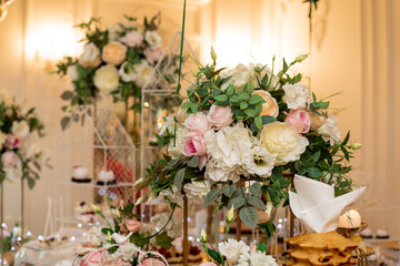 Luxurious floral arrangements in decoration of sweet buffet at wedding ceremony. Delicious wedding buffet . Festive event. Organization weddings. Wedding floristry