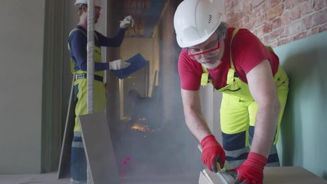 Professional builders in safety uniform renovate apartment. Realtime