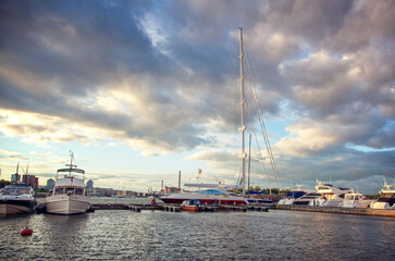 Fototapeta na wymiar Port in european city with white boats and yachts at sunset