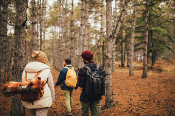 Fototapeta premium Group of friends travelers with backpacks hiking in a forest. Wanderlust concept.