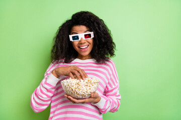 Portrait of attractive cheerful funny girl wearing 3d specs eating corn rest having fun isolated over shine green color background