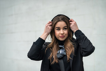 pretty brunette in classic black clothes on the streets of a cool city.